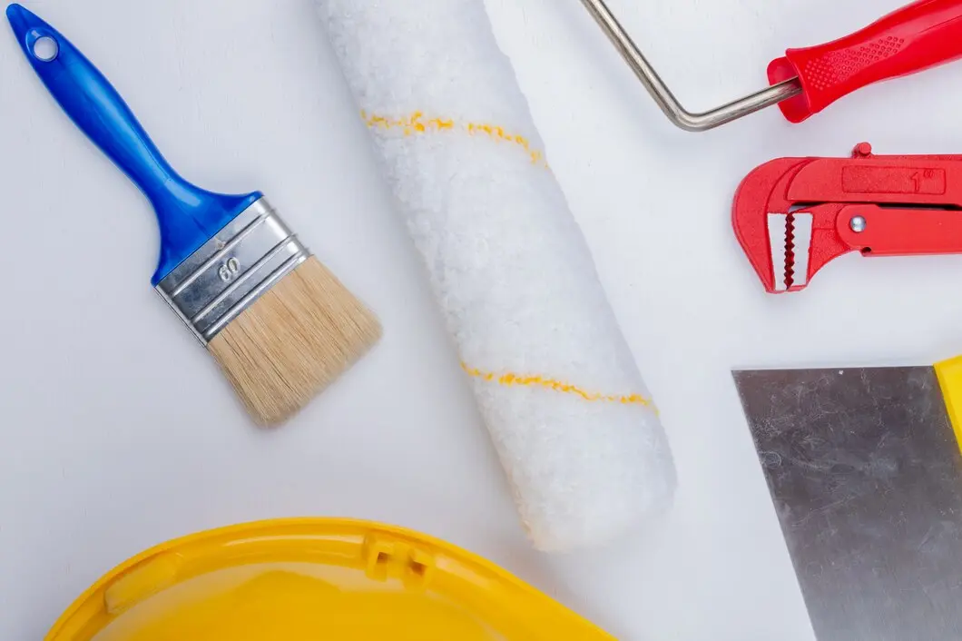 close up view construction tools as paint brush roller safety helmet pipe wrench putty knife white background 141793 14212